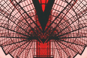 Abstract view of a red geometric architectural structure, showcasing modern design and symmetry.